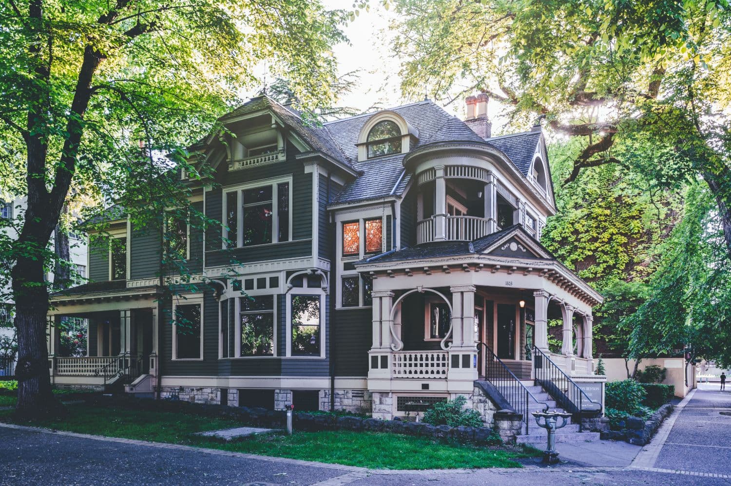A restored Victorian home framed by trees