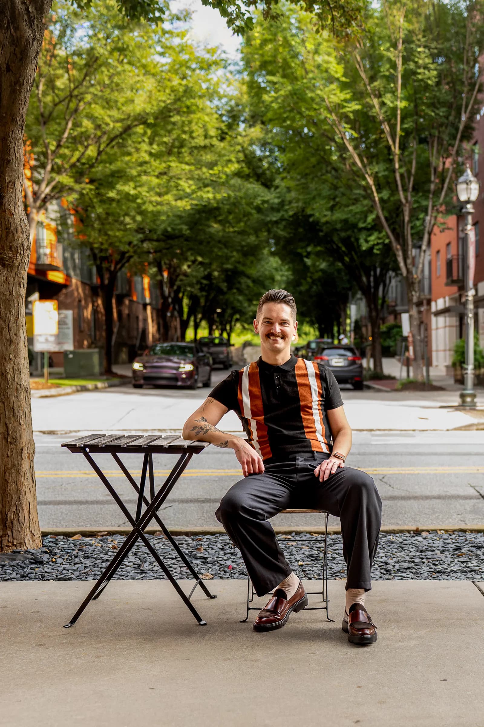 Cory Klose seated on a tree-lined intown Atlanta street